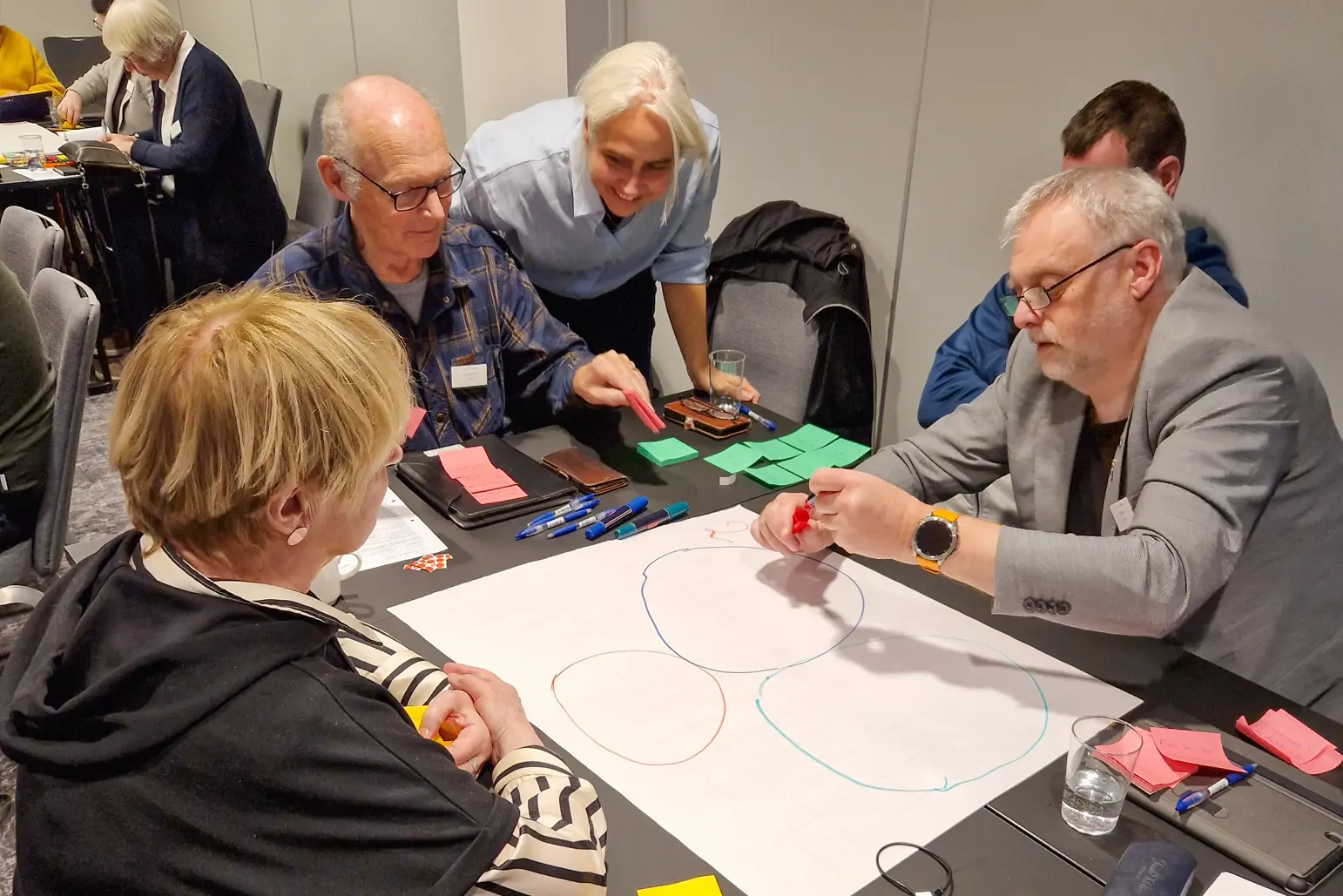 Mennesker rundt et bord som samarbeider