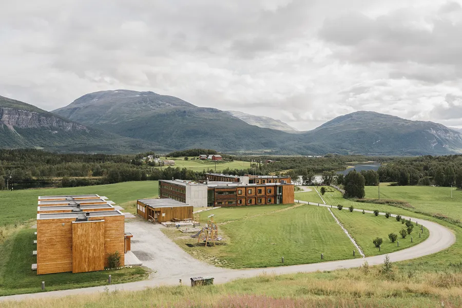 En bygning med vei og fjell i bakgrunnen