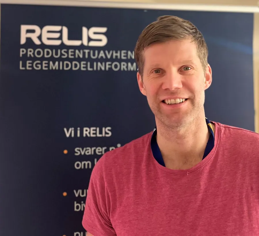 En mann som smiler til kameraet