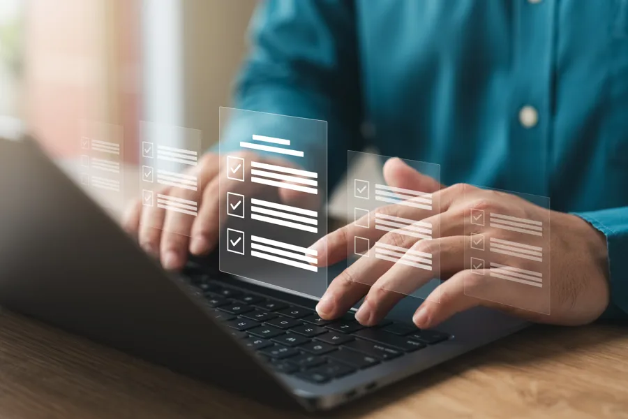 person sitter ved bærbar datamaskin og fyller ut et digitalt pasientskjema