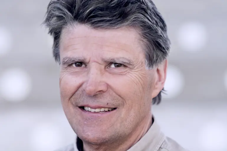 En mann som smiler til kameraet