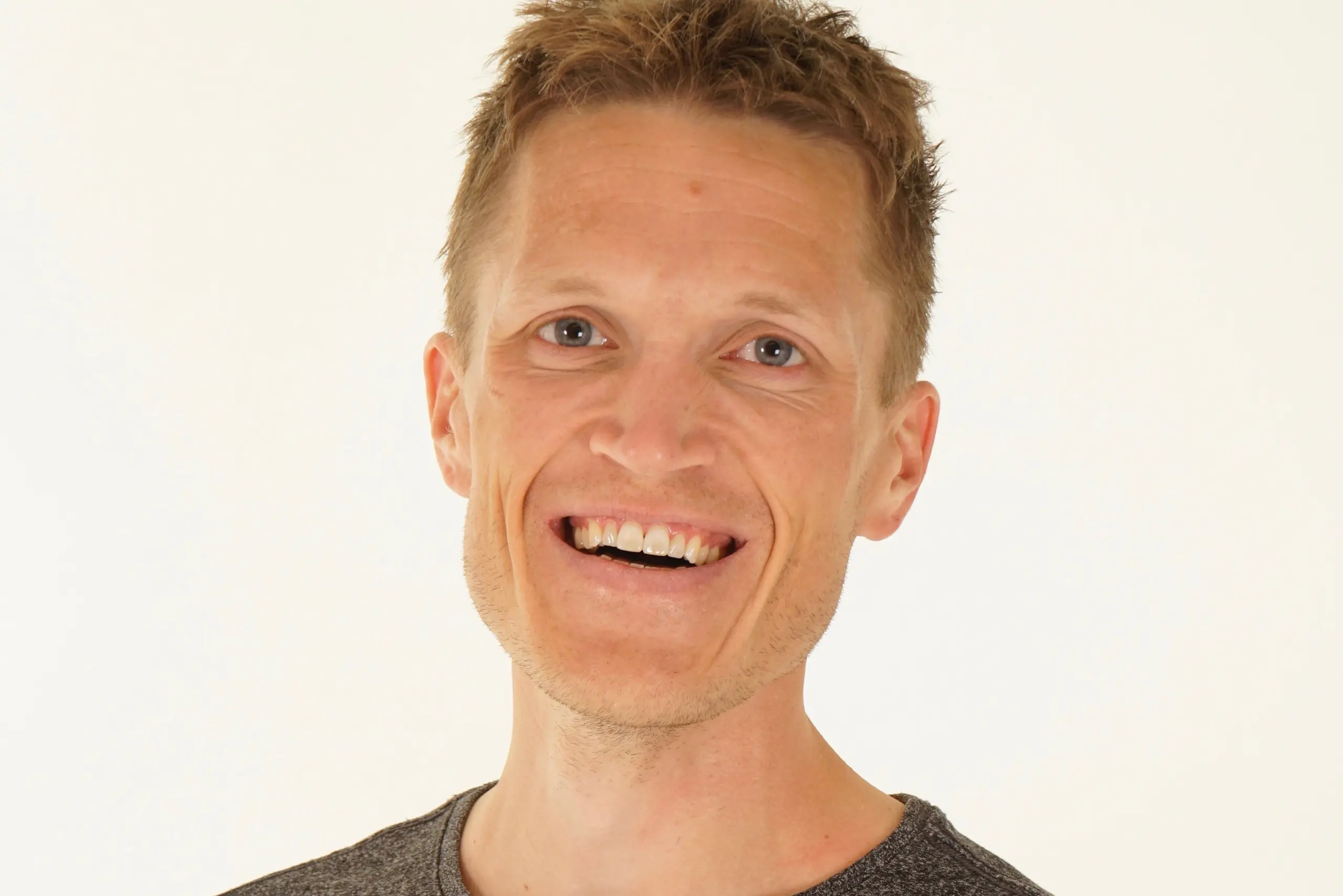 En mann som smiler til kameraet