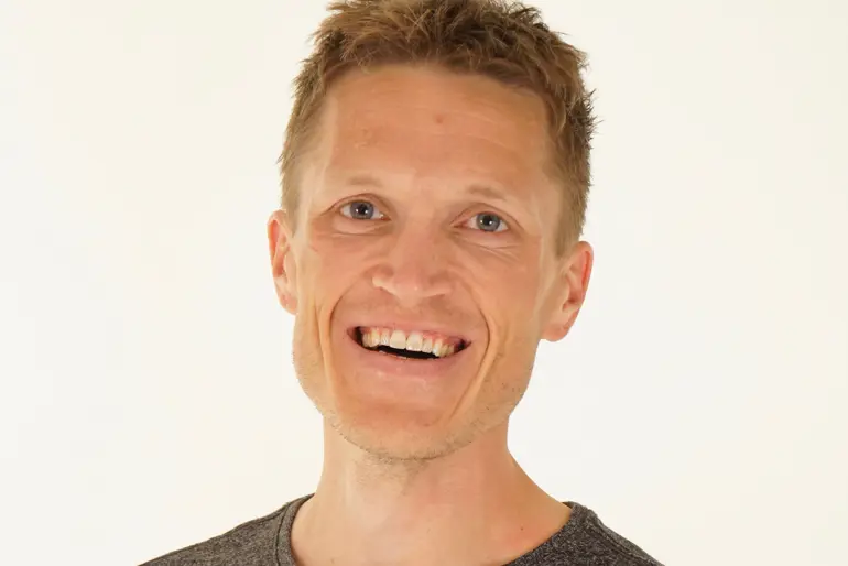 En mann som smiler til kameraet