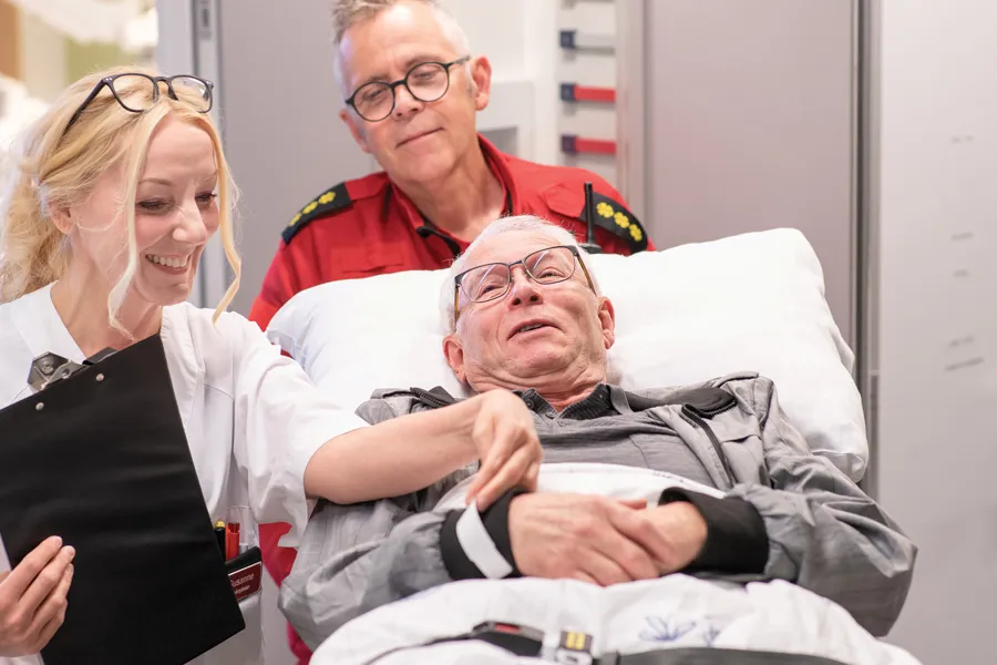 En kvinne som holder en mann i en sykehusseng