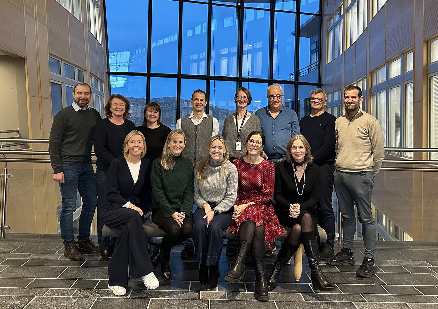 En gruppe mennesker smiler mot kamera