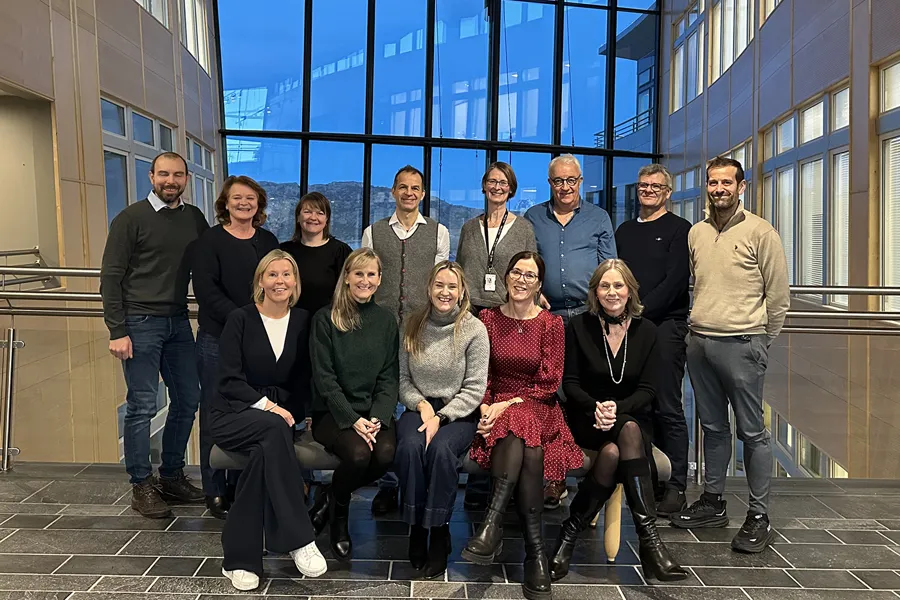 En gruppe mennesker smiler mot kamera