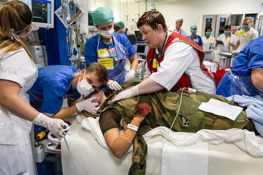 Helsepersonell behandler en skadet soldat