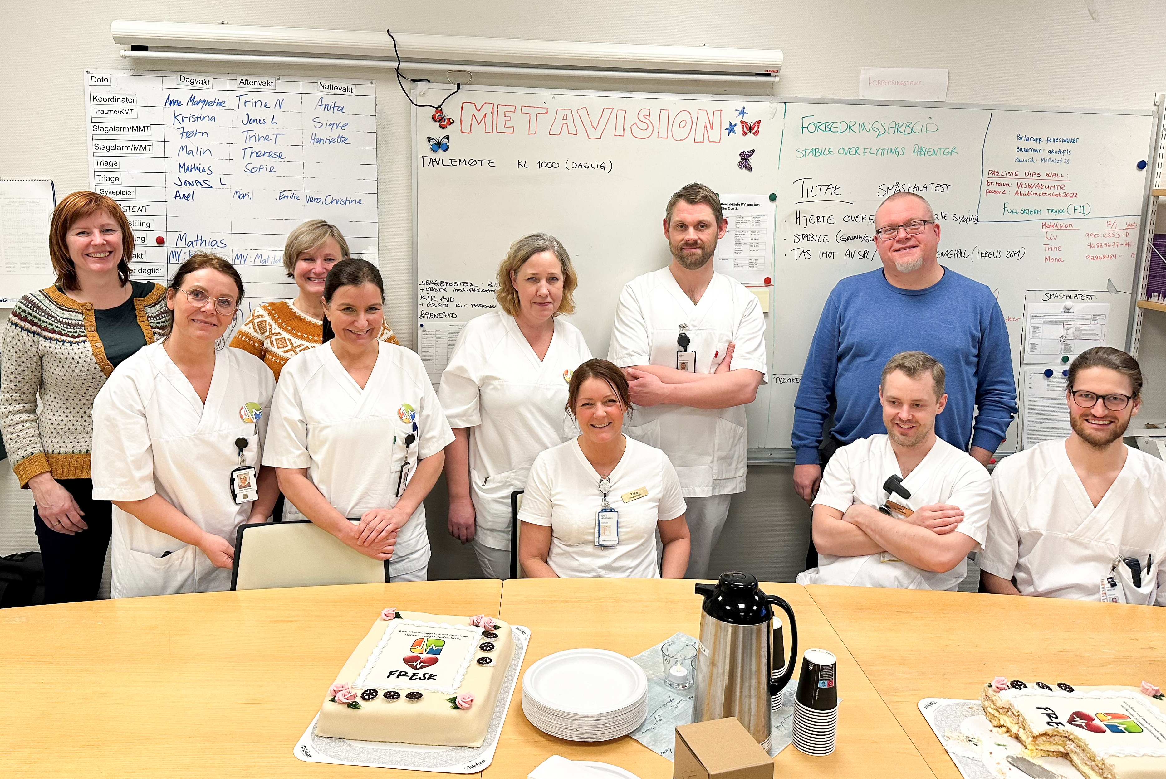 En gruppe mennesker i hvitt med kake