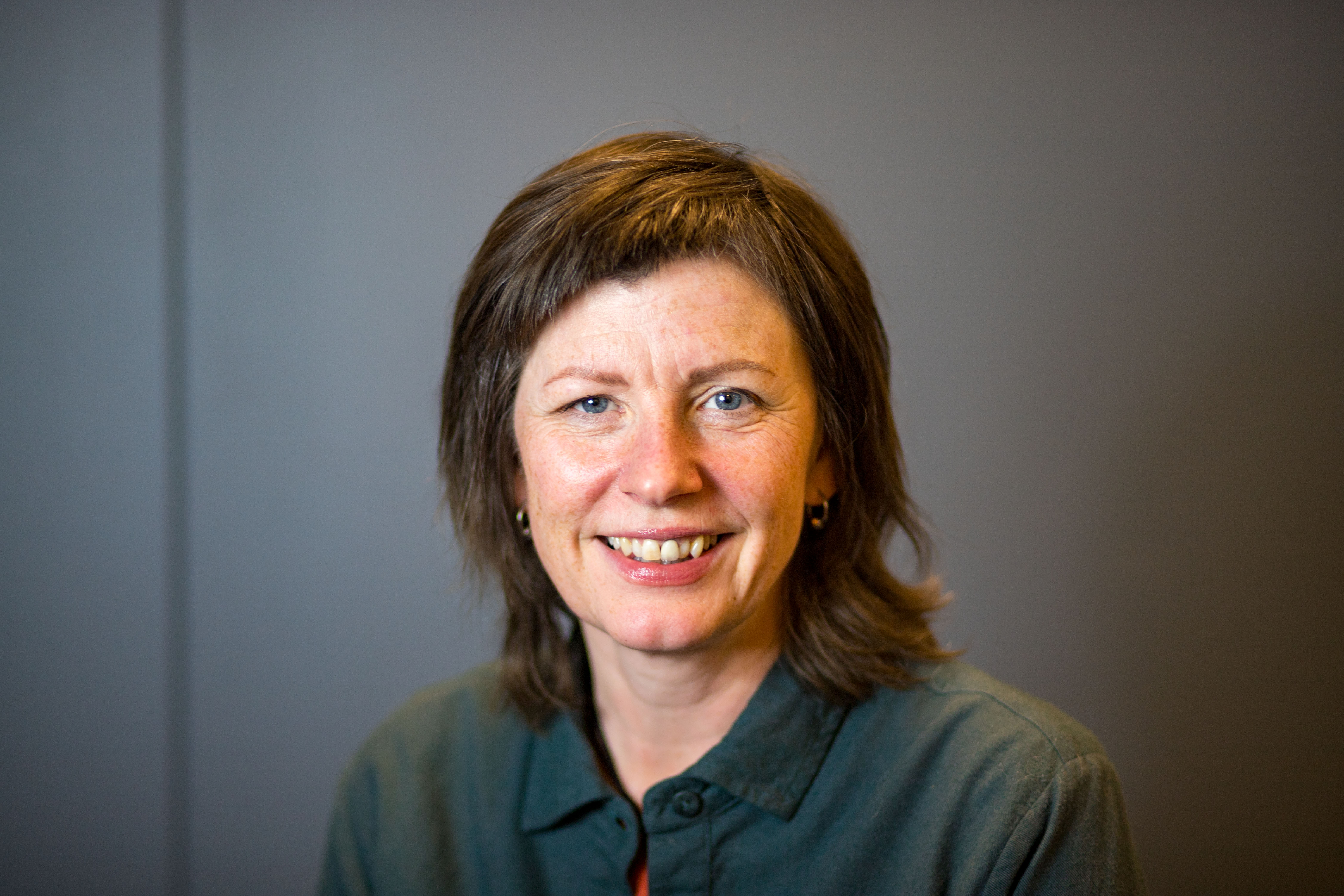 En kvinne som smiler til kameraet