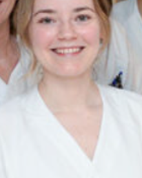 En kvinne som smiler til kameraet