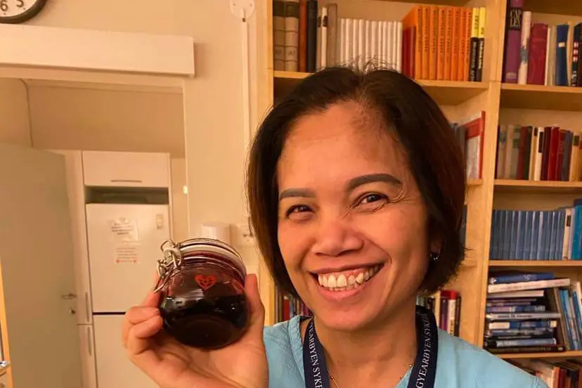 En kvinne som holder en liten svart gjenstand