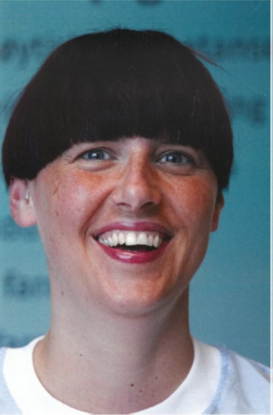 En kvinne som smiler til kameraet