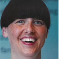 En kvinne som smiler til kameraet